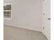 A bright bedroom featuring neutral carpet, a window and a white paneled door at 290 Halibut Cir, Covington, GA 30016