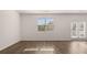 Spacious living area with a window and French doors, showcasing modern flooring and neutral walls at 290 Halibut Cir, Covington, GA 30016