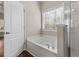 Relaxing bathroom with tub, shower and natural light from a window with white blinds at 3565 Mystic Dr, Buford, GA 30519