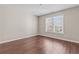 Bedroom with a large window allowing natural light, neutral paint, and beautiful floors at 3565 Mystic Dr, Buford, GA 30519