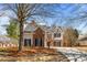 Beautiful two-story home with a brick facade, complemented by a lush, tree-filled yard at 3565 Mystic Dr, Buford, GA 30519