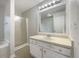This bathroom features a vanity sink, white cabinets, a large mirror, and a shower/tub combo at 17 Cedars Glen Pl, Villa Rica, GA 30180