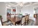 Open-concept dining room with coffered ceilings, modern lighting, and a view into the living spaces at 2102 Democracy Dr, Buford, GA 30519