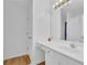 Bright bathroom featuring a white vanity, large mirror, and wood-look flooring at 2612 Kirkhill Ct, Lawrenceville, GA 30044