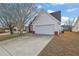 Charming home exterior featuring a two-car garage, vinyl siding, and well-maintained landscaping at 2612 Kirkhill Ct, Lawrenceville, GA 30044