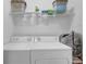 Well-organized laundry room with newer washer and dryer units and overhead storage at 2612 Kirkhill Ct, Lawrenceville, GA 30044