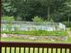 View from the back deck showcases a serene outdoor retreat with a fenced pool and lush greenery at 1931 Harvest Way, Loganville, GA 30052