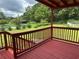 Back deck featuring a view of the in-ground pool, manicured landscaping, and mature trees at 1931 Harvest Way, Loganville, GA 30052