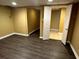 Wood-look flooring and neutral paint leads to another room with tile flooring in basement at 1931 Harvest Way, Loganville, GA 30052