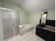 Bright bathroom with tiled shower, soaker tub, and single dark vanity at 1931 Harvest Way, Loganville, GA 30052