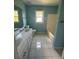 Bright bathroom featuring dual vanity, white cabinets, tile flooring, tub and window at 1931 Harvest Way, Loganville, GA 30052