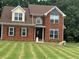 Charming two-story brick home featuring a well-manicured lawn, updated windows, and inviting front entrance at 1931 Harvest Way, Loganville, GA 30052