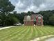 Charming two-story brick home with manicured lawn and long driveway, offering curb appeal and space at 1931 Harvest Way, Loganville, GA 30052