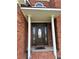 Inviting brick home entrance with classic front door and decorative sidelights on a covered porch at 1931 Harvest Way, Loganville, GA 30052