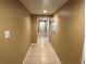 Long hallway with neutral paint and tiled floor leads to various rooms in this home at 1931 Harvest Way, Loganville, GA 30052