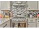 Modern kitchen featuring a stainless steel range and decorative tile backsplash at 2738 Allyn Nw Way, Kennesaw, GA 30152