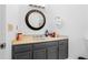 Bathroom featuring vanity with a gray cabinet, and a round mirror at 3670 River Mansion Dr, Peachtree Corners, GA 30096