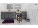 Bathroom with gray vanity, dual mirrors, wood stool and tiled floors and fresh towels on the rack at 3670 River Mansion Dr, Peachtree Corners, GA 30096