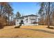 Elegant white home with a grand entrance, multiple balconies, and mature trees on a well-manicured lawn at 3670 River Mansion Dr, Peachtree Corners, GA 30096