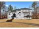 Elegant white home with a grand entrance, multiple balconies, and mature trees on a well-manicured lawn at 3670 River Mansion Dr, Peachtree Corners, GA 30096