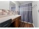 Cozy bathroom with wood-look flooring, tiled backsplash, vanity with storage, and a shower with curtain rod at 236 Rankin Cir, Mcdonough, GA 30253