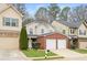 View of a cozy two-story home showcasing the attached two-car garage and small front yard at 236 Rankin Cir, Mcdonough, GA 30253