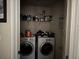 Practical laundry room with washer, dryer, and shelving offers efficient cleaning space at 3429 Lake End Dr, Loganville, GA 30052