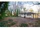 A view of the backyard, showcasing the covered parking, nice lawn and surrounding trees at 2895 Akron St, Atlanta, GA 30344