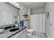Neutrally decorated bathroom with gray stone countertops, and tub with shower at 3488 In Bloom Way, Auburn, GA 30011