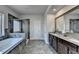 Elegant bathroom with a soaking tub, glass shower and double vanity sinks at 3488 In Bloom Way, Auburn, GA 30011