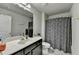 Bathroom features a sink, vanity, toilet, and shower with patterned curtain at 3488 In Bloom Way, Auburn, GA 30011