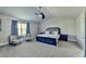 Primary bedroom with neutral walls, light carpet, and seating near a bright window at 3488 In Bloom Way, Auburn, GA 30011