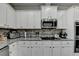 Modern kitchen featuring white cabinets, granite countertops, and stainless steel appliances at 3488 In Bloom Way, Auburn, GA 30011