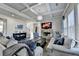 Cozy living room featuring coffered ceilings, stone fireplace, and hardwood floors at 3488 In Bloom Way, Auburn, GA 30011