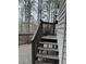 Exterior view of the wooden deck with stairs leading up to an elevated, wooded yard at 911 Laurel Crest Dr, Woodstock, GA 30189