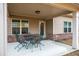 Covered back patio with table and chairs, with a view to the backyard at 1187 Kingston Hill Dr, Loganville, GA 30052