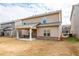 View of the back of the house with a covered back patio and neutral colored siding, and a dry lawn at 1187 Kingston Hill Dr, Loganville, GA 30052