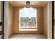 A balcony featuring tile flooring, a small white wooden railing, and an arched window overlooking a residential street at 1187 Kingston Hill Dr, Loganville, GA 30052