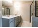 Bathroom with double vanity, a large framed mirror, white countertops, a glass shower, and gray cabinetry at 1187 Kingston Hill Dr, Loganville, GA 30052