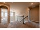 Upstairs hallway with neutral carpeting, an arched doorway, and views of the staircase and a bedroom at 1187 Kingston Hill Dr, Loganville, GA 30052