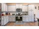 Well-equipped kitchen with stainless steel appliances, gray cabinets, tile backsplash, and granite countertops at 1187 Kingston Hill Dr, Loganville, GA 30052
