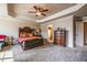 A large primary bedroom featuring neutral walls, a tray ceiling with fan, carpeted floors, and dresser at 1187 Kingston Hill Dr, Loganville, GA 30052