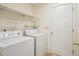 Well-lit laundry room with washer, dryer, and convenient storage shelves at 3815 Glen Laurel Ct, Cumming, GA 30040