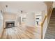 Open-concept living space with fireplace and wood-look floors, adjacent to modern kitchen at 3815 Glen Laurel Ct, Cumming, GA 30040