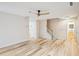 Bright living room featuring wood floors, a modern ceiling fan, and staircase with white risers and natural wood handrail at 3815 Glen Laurel Ct, Cumming, GA 30040