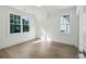 Sunlit bedroom with hardwood floors, white walls, and two windows at 114 Terrace Ne Dr, Atlanta, GA 30305