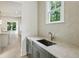 Convenient butler's pantry featuring custom cabinets, stone counters, and stainless faucet at 114 Terrace Ne Dr, Atlanta, GA 30305