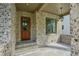 Inviting front porch featuring brick detail, stone flooring, and stylish lighting fixture at 114 Terrace Ne Dr, Atlanta, GA 30305