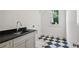 Bright laundry room with black and white checkered floor and granite countertops at 114 Terrace Ne Dr, Atlanta, GA 30305