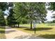 Walking trail along golf course and pond with signs that read, 